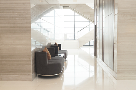 Modern sofa in lobby of hotel with glass window backgroundの写真素材