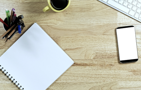 Blank white Paper and smart phone with  black screen and the cup of coffee and office supply for working business communication concept.の写真素材
