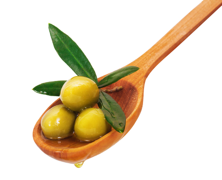 Green olives on a wooden spoon. Isolated on white backgroundの写真素材