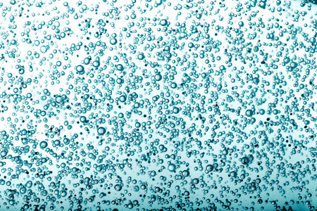 Oxygen bubbles in clear blue water, close-up. Mineral water. Water enriched with oxygen.