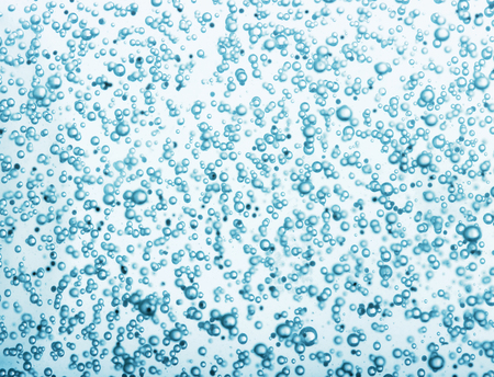 Oxygen bubbles in clear blue water, close-up. Mineral water. Water enriched with oxygen.の写真素材