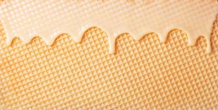 White hot chocolate on the wafer. Waffle covered with condensed milk close-up. White hot chocolate spreads on the wafer.の写真素材