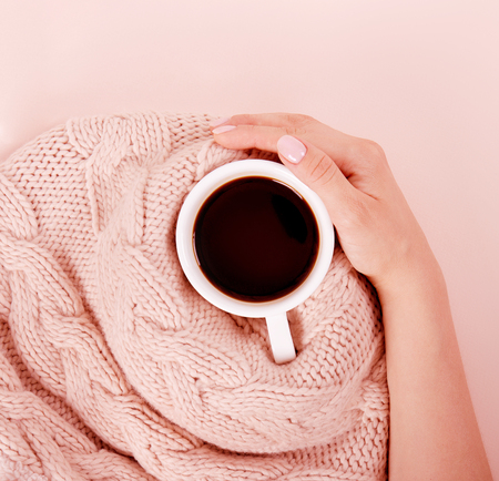 Woman with a cup of fragrant coffee in her hands on a cool day. Black warm coffee in cold weather. View from above.の写真素材