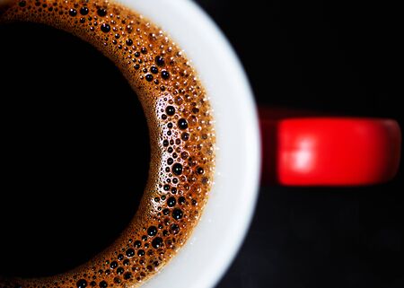 Fragrant black coffee in a cup. Smoke from black hot coffee. Advertising coffee.の写真素材