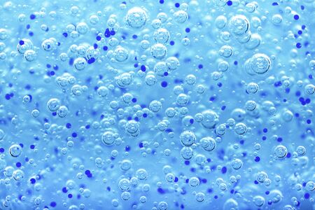 Transparent gel with bubbles close-up. The texture of gel cream. Oxygen bubbles in clear blue water, close-up. Mineral water. Water enriched with oxygen.の写真素材