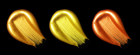 Creative brushstrokes of gold paint isolated on a black