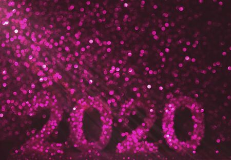 The numbers 2020 are written from sparkles. Template for a festive New Year card from beautiful bokeh. Happy New Year 2020.の写真素材