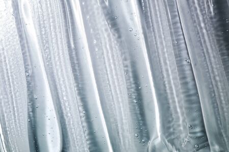 Transparent gel with bubbles close-up. Smear of face gel cream. The texture of gel cream. A sample of a cosmetic product. Antibacterial gel.の写真素材