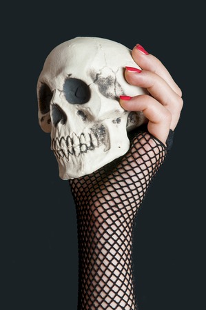 Skull  in the hand with red nails on black backgroundの写真素材