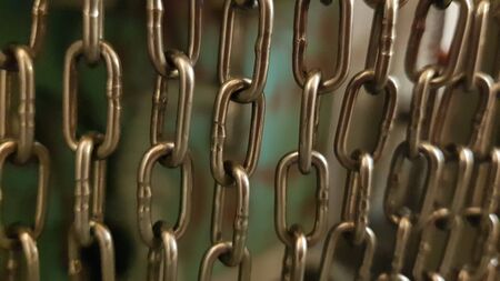 Rough metal chains pattern textured background with blurry frame edges. Selective focus to chains hanging in rows. Industrial backdropの写真素材
