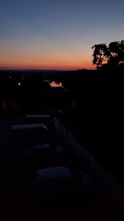 Blur abstract view of sunrise in darkness with tree silhouettes. Defocus landscape of sun dawn in...