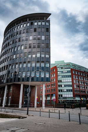 Hamburg / Germany - 09 05 2018: Low angle view to city street with modern corporate building on overcast sky backgroundのeditorial素材