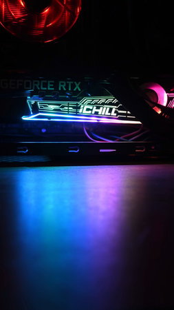 Vertical shot with blue illuminated blurred foreground for copy space. Gaming PC tower with NVidia...