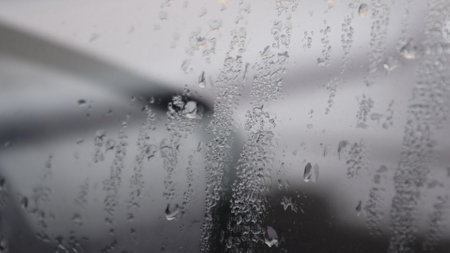 Defocus background of drops on glass surface of car window. Wet car window glass texture backgroundの写真素材