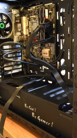 Closeup inside gaming PC tower with motherboard mini-ITX installed inside. Cooler fan and hardware...