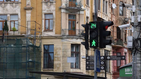 Green light of pedestrian traffic light with urban background of tourist signs and security cameras. Countdown display of traffic light in old town of Lviv, Ukraine, 10 06 2020のeditorial素材