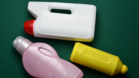 White, pink and yellow plastic bottles from recyclable type of polymer. Used plastic cans with...