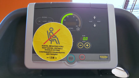 Yellow sticker warning about keeping social distance in Turkish, English, German, Russian languages....