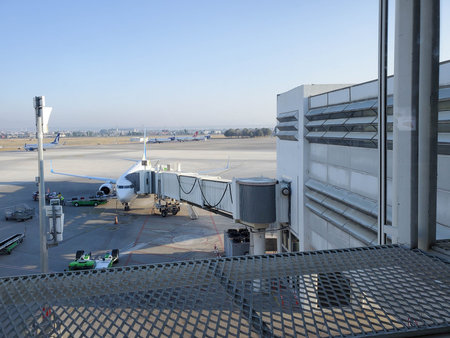 Aircraft at boarding bridge jetway connected to airplane for boarding passengers. Jet bridge movable...