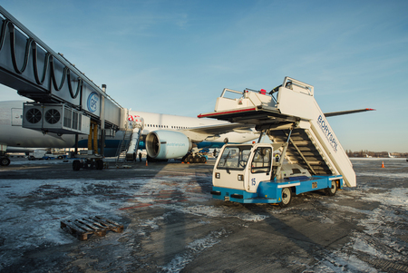 Boryspil, Ukraine - December 07, 2016; Service ladder car on the airfield of airport near the plane ready to transportationのeditorial素材