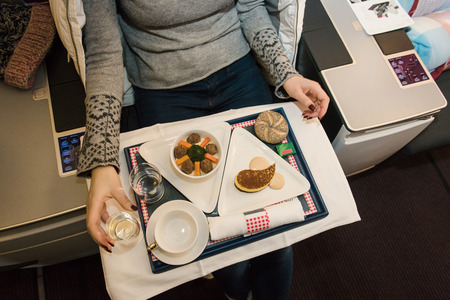Food served on board of business class airplane on the table. Fresh meal with desert and glass of wine for passenger. Tasty cuisine and catering.の写真素材