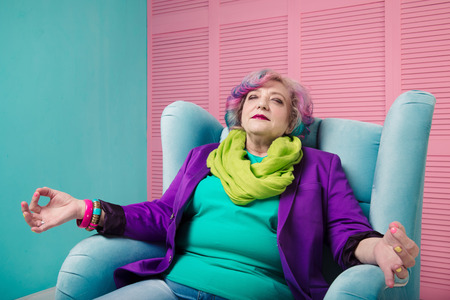 Retired woman enjoy life and relaxing in blue armchair, meditating and dreaming.の写真素材
