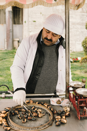Turkey, Istanbul - March 31, 2017: Seller with cart of grilled chestnuts on the street of Istanbul, square Sultanahmet.のeditorial素材