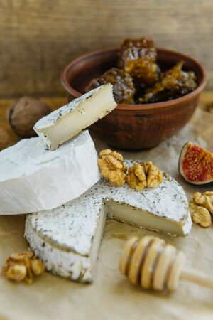 Set of craft camembert, brie cheese with herbs, fresh fruits (fig) honey comb from farmers market.の写真素材