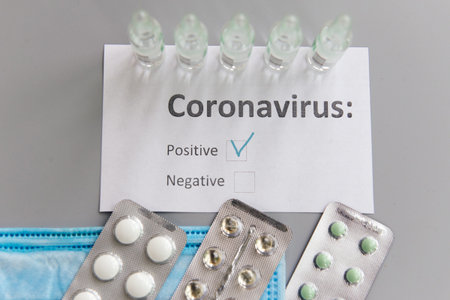 Coronavirus test  positive result mark, text on paper, colorful effect. Medicines, pills, ampoules...