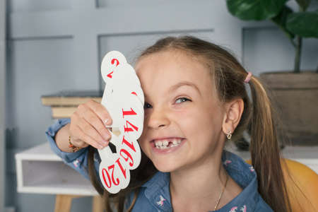 Little school girl learning numbers and to count at home. Happy cute child playing with lots of colorful plastic digitsの写真素材