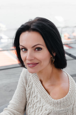 Stylish woman outdoors on terrace in the city. Portrait of adult stylish model in her 40s,