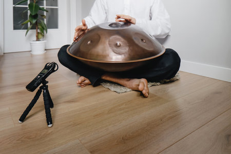 Man playing on hang drum, or Steel Drum, Hangpan, modern steel music instrument at home. Recording sound for Meditation music for relax. Close-upの写真素材