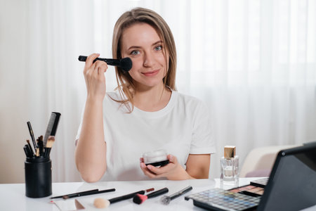 Woman doing make-up at home, apply decorative cosmetics. Beautiful young female using brush near the...