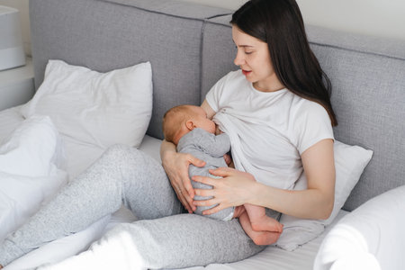 Breast feeding mama at home. Baby breastfeed on mothers hands, Cuddle a baby and talking to son