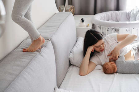 Breast feeding mama at home. Baby breastfeed on mothers hands, Cuddle a baby and talking to sonの写真素材