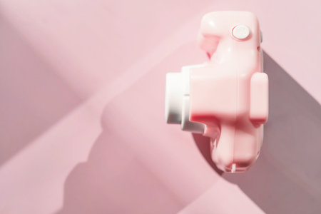 Light pink toy camera on pastel background, top view, shadow. Future digital photographer deviceの写真素材