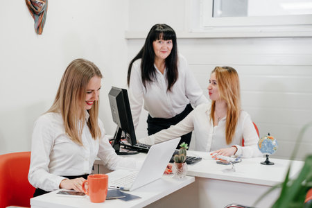 Travel agency working on-line in office, communicating with clients via phone and Internet over the world map. Manager gives information online, consulting touristsの写真素材