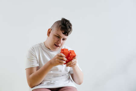 Disabled teenage child build from blocks Boy with cerebral palsy doing activities for Children with Special Needs over white background. creativity, fine motor skills, rehabilitation, learning at homeの写真素材