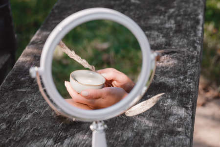 Tea cup reflection at the round mirror on wooden table. Soul and spirit, romantic, taste, tenderness outdoors concept. Copy space, beautyの写真素材