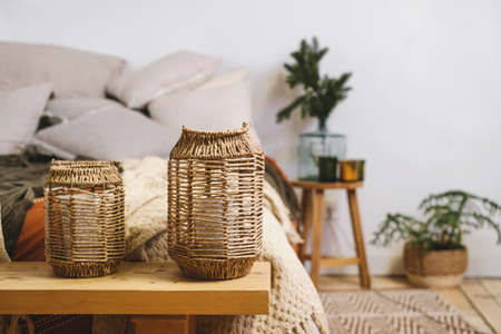 Livingroom Christmas decor near bed in eco style, natural elements and real fir tree in pot and branches in vase. Scandinavian stile, rustic home Copy space Cozy house with candles and wooden floorの写真素材