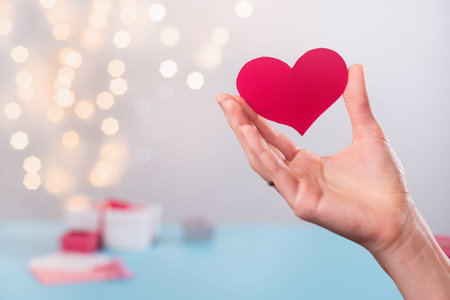St. Valentines Day symbol of love heart shape in hands. Copy space for love message. Choose New Year...