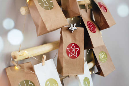Christmas advent calendar for kids, creative tasks in paper bags for everyday. 24 handmade numbered bags with gifts. Countdown to Christmas Eve. Close-upの写真素材