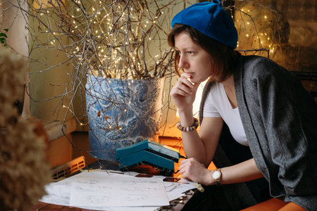 Creative young woman artist in atmospheric studio. Portrait of female in retro style. Authentic...