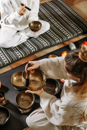 Singing bowls top view, sound healing alternative therapy. Woman playing on percussion metal music...
