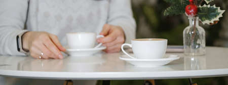 Woman drinking coffee in cafe in winter. Dreamy relaxed adult female in her 40s.の写真素材