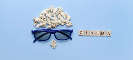 Banner Pop Corn man face on blue background. Cinema concept. Top view flat lay with copy space. 3D eye glasses for romantic movie for couple.の写真素材
