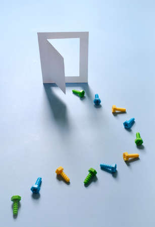 Enter the door of house on blue by bolts as visitor Creative concept. Balance, shadows Step by step into opened entrance progress, colorful screw and building, construction improvement tool Copy spaceの写真素材