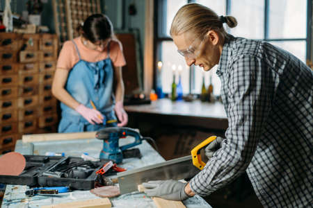 Man and woman working in workshop, doing furniture, reuse old materials to new product. awareness in consumption. Small family business. Recycling, sustainability refurbishments maintenance for homeの写真素材