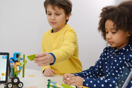 Students In School Computer Coding Class Building And Learning To Program Robot Vehicle. Multi...