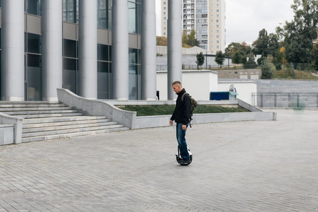 Man riding fast on electric unicycle on city street. Mobile portable individual transportation...